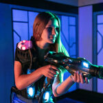 Girl wearing CyberBlast Pro laser tag vest and holding phaser
