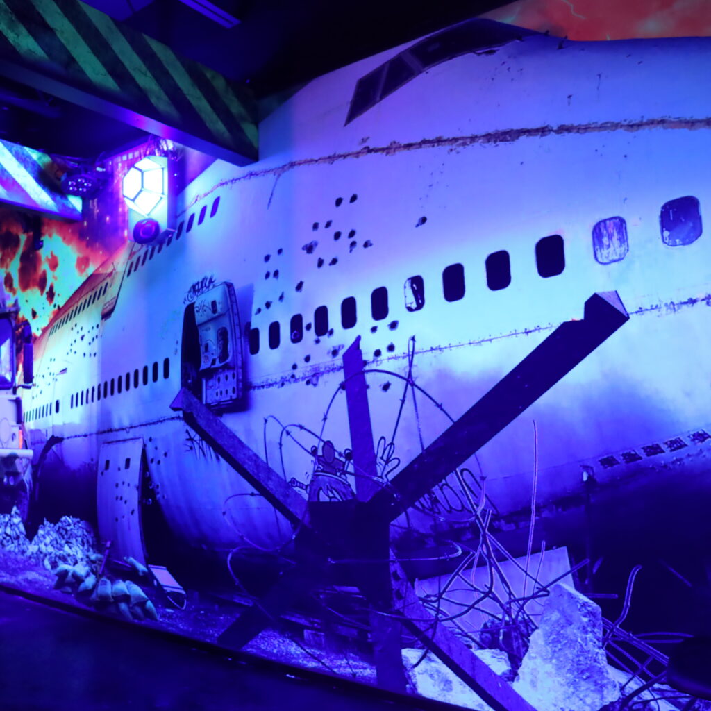 Crashed airplane wall art with an illuminated base on it.