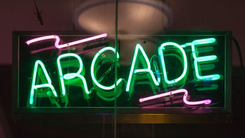 Green and pink lit up Arcade neon light sign.