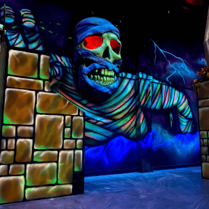 Mummy prop coming out of the wall from a laser tag arena.