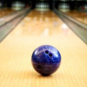 Blue bowling ball sitting on a bowling lane