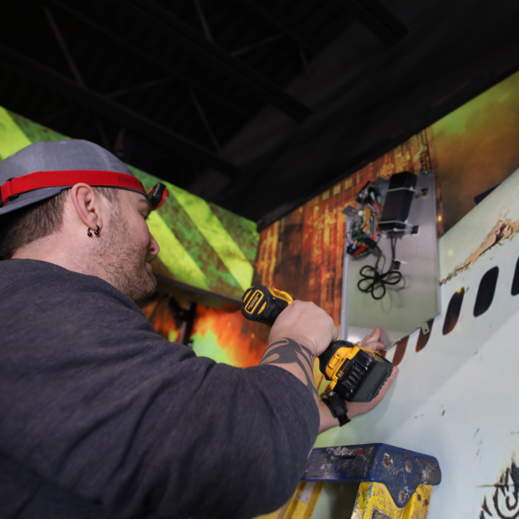 Man installing a base station in a laser tag arena.