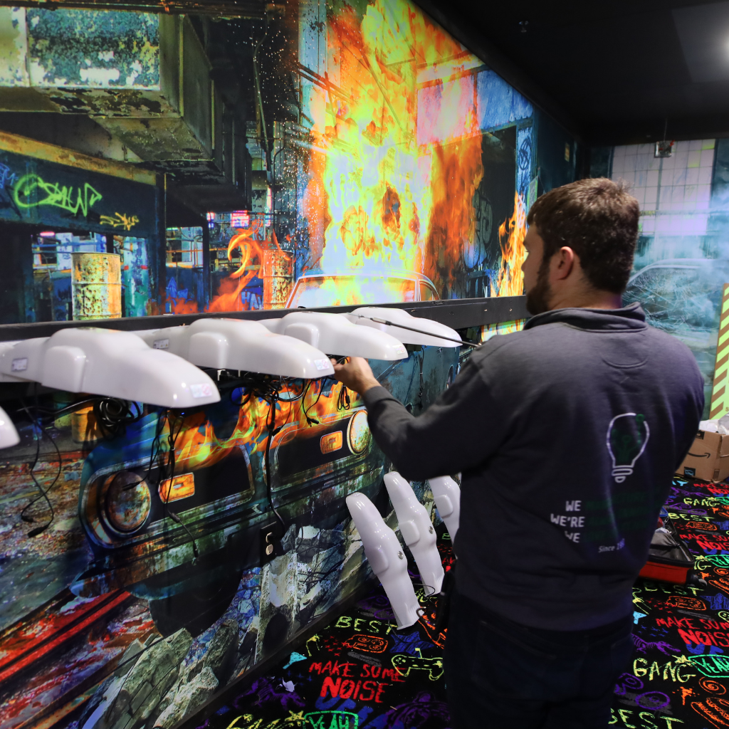 Man installing wireless charging racks in a laser tag arena.