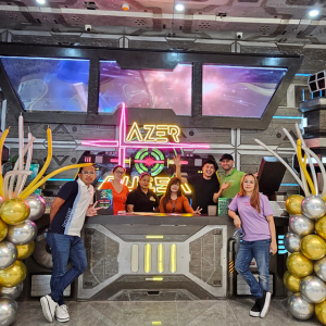 Front desk with staff standing at it at a laser tag facility.