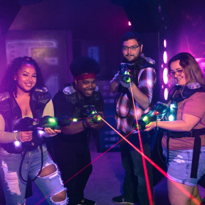 Group of for people in CyberBlast Pro laser tag gear with three of them triggering their red aiming lasers.