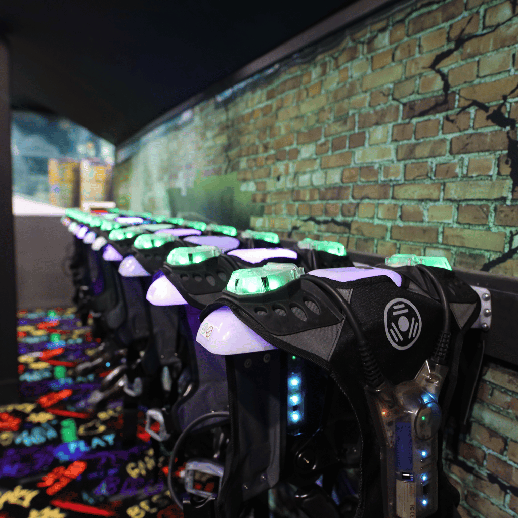 CyberBlast laser tag vests on wireless charging racks in vesting room.