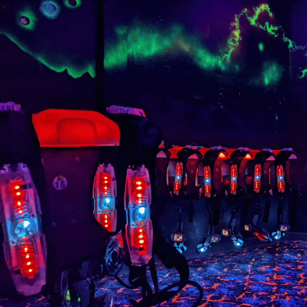 CyberBlast laser tag vests on wireless charging racks in vesting room.