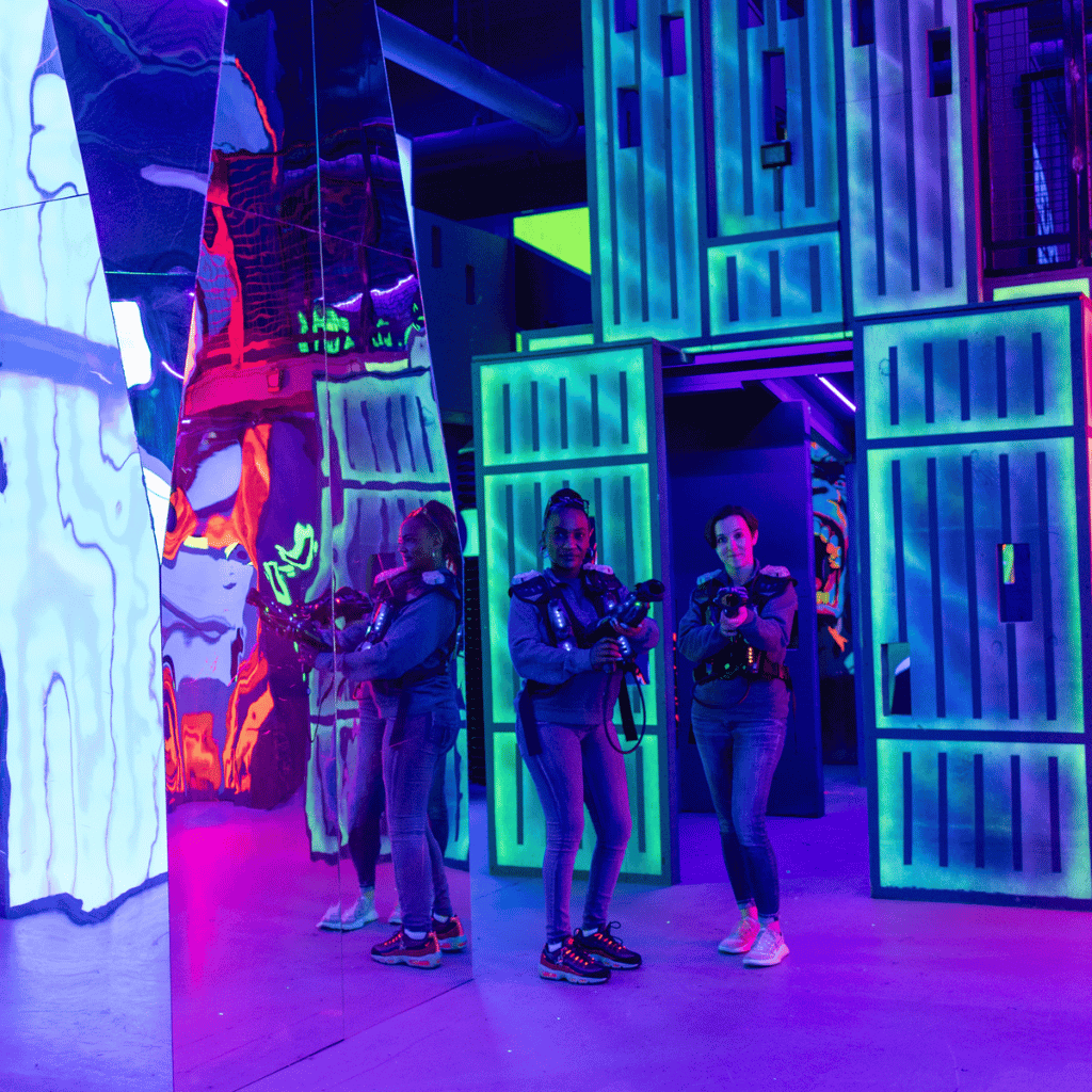 Two women standing in a laser tag arena together wearing CyberBlast laser tag gear.
