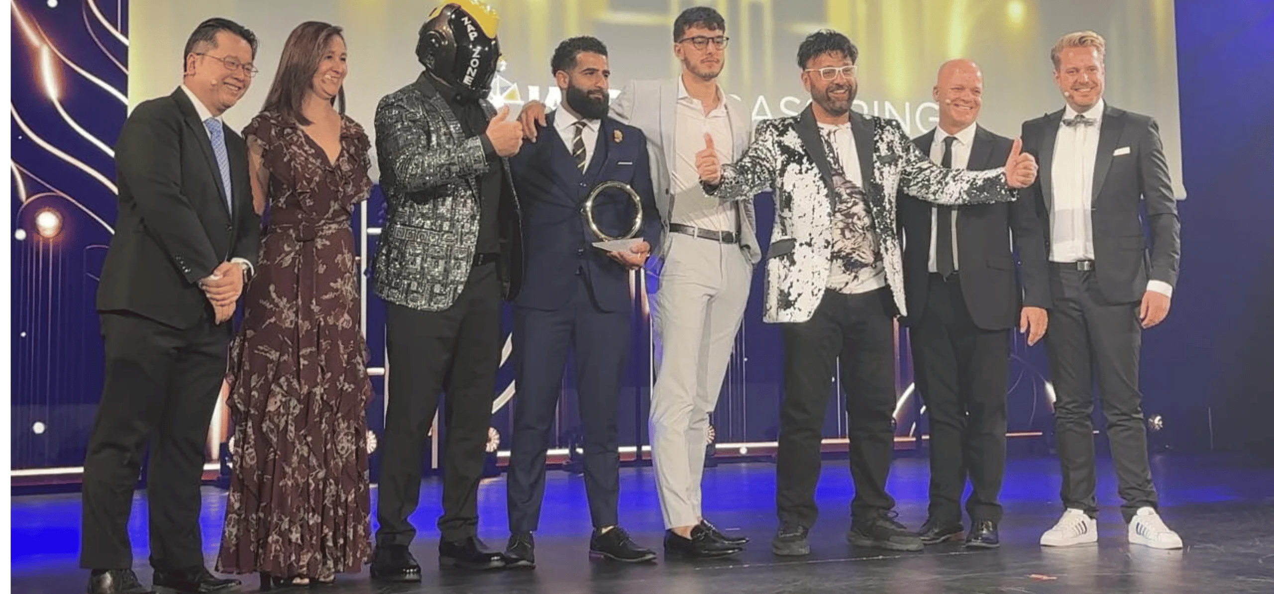 A line of men and woman on a stage in dress attire at the IAAPA Honors award ceremony.