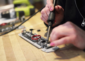 Hands soldering a piece of laser tag equipment.